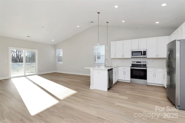 kitchen featuring white cabinets, appliances with stainless steel finishes, hanging light fixtures, and sink