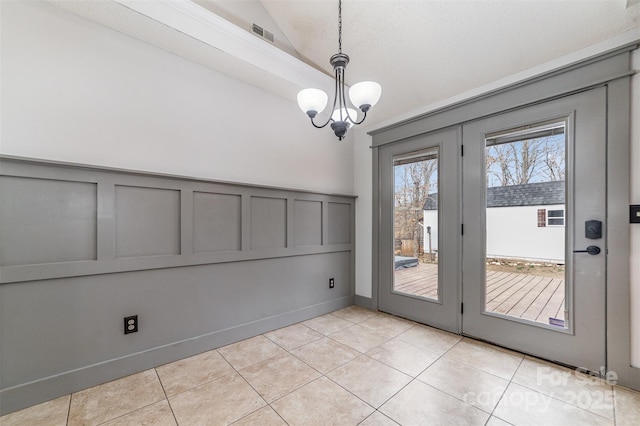 doorway to outside featuring lofted ceiling, a notable chandelier, and light tile patterned flooring