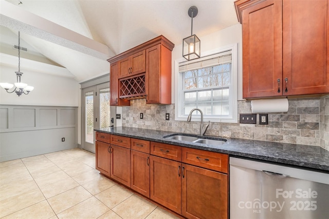 kitchen featuring lofted ceiling, sink, decorative light fixtures, and dishwasher