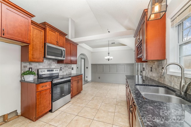 kitchen featuring pendant lighting, appliances with stainless steel finishes, sink, and dark stone counters