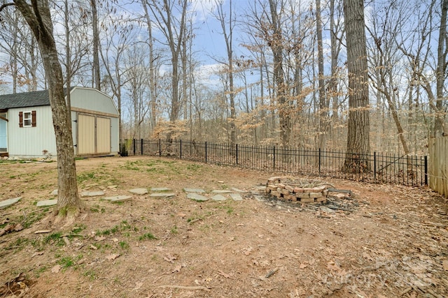 view of yard featuring a storage shed and a fire pit