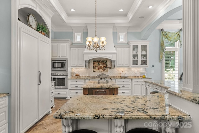 kitchen featuring a kitchen breakfast bar, a center island, stainless steel appliances, and decorative light fixtures