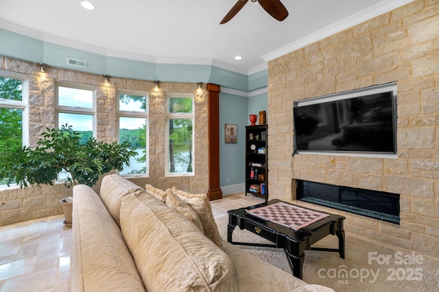 living room with ceiling fan, a fireplace, and ornamental molding