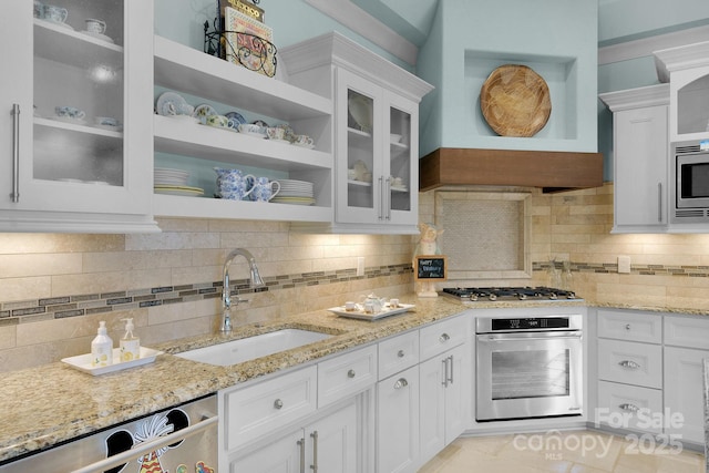 kitchen with decorative backsplash, stainless steel appliances, white cabinetry, and sink