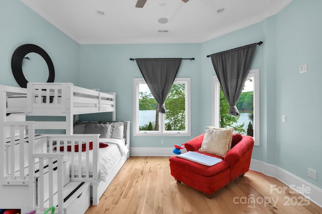 bedroom featuring ceiling fan, light wood-type flooring, and ornamental molding