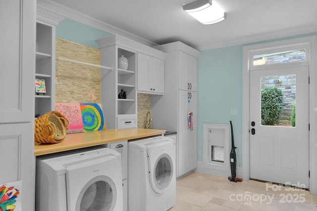 clothes washing area featuring ornamental molding, cabinets, and independent washer and dryer