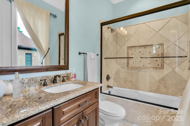 full bathroom featuring vanity, toilet, and bath / shower combo with glass door