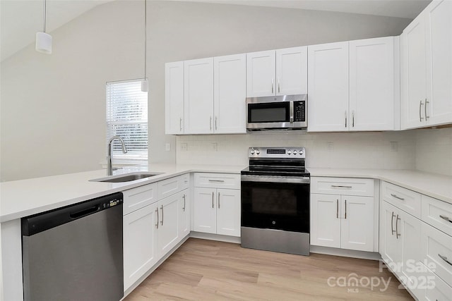 kitchen with white cabinetry, decorative light fixtures, and stainless steel appliances