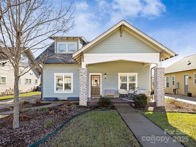 view of front of house featuring covered porch and a front lawn