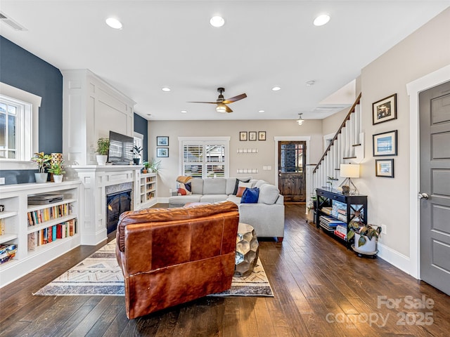 living room with ceiling fan, a fireplace, and dark hardwood / wood-style floors