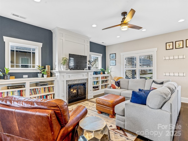 living room featuring ceiling fan and a high end fireplace