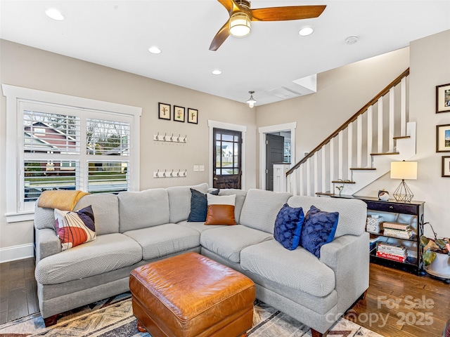 living room featuring ceiling fan, dark wood-type flooring, and a healthy amount of sunlight