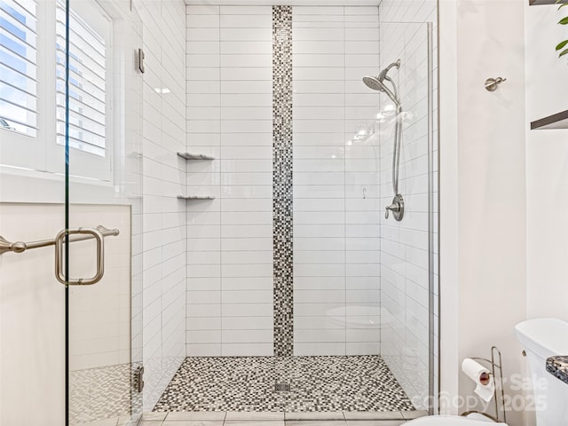 bathroom featuring toilet and an enclosed shower