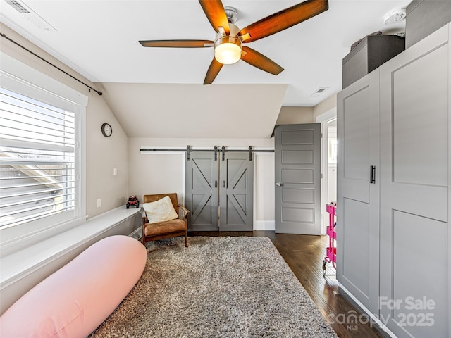 living area with vaulted ceiling, a barn door, ceiling fan, and dark hardwood / wood-style floors