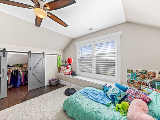 bedroom featuring a barn door, a closet, ceiling fan, and lofted ceiling