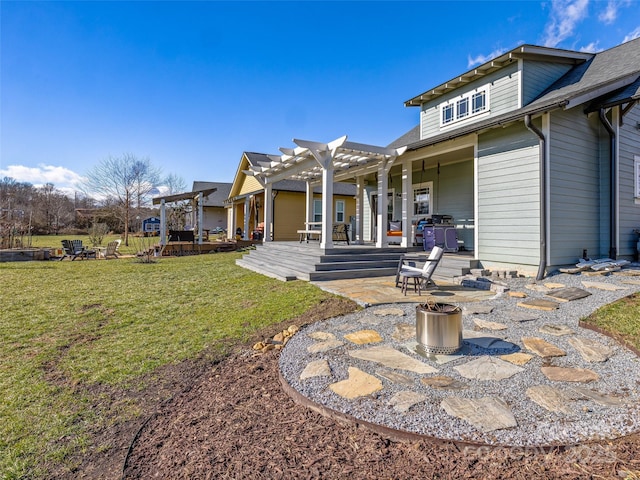 rear view of property featuring a pergola, a lawn, and a patio