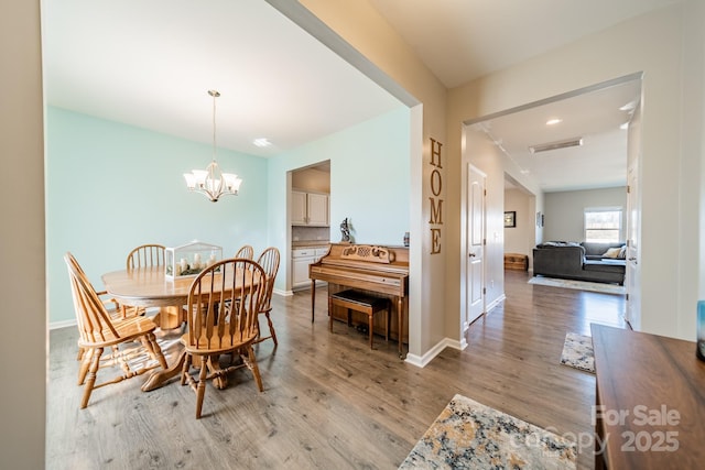 dining area featuring light hardwood / wood-style floors and a chandelier