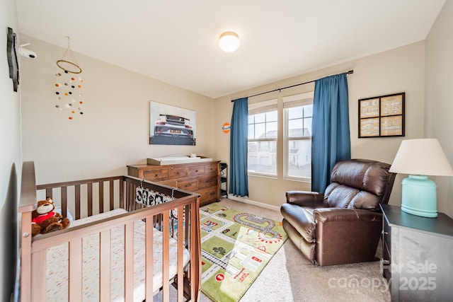 bedroom featuring carpet and a nursery area