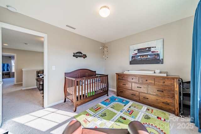 carpeted bedroom with a nursery area