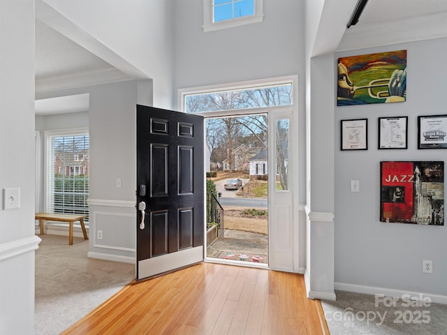 carpeted foyer with ornamental molding