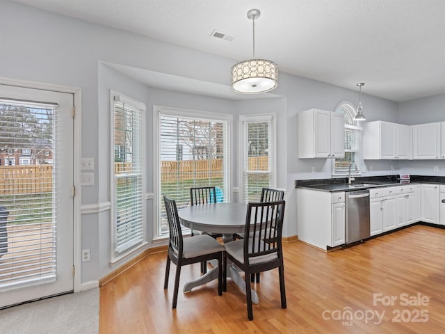 dining area with sink, a wealth of natural light, and light hardwood / wood-style floors