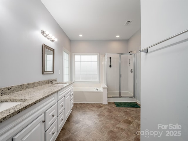 bathroom featuring vanity and independent shower and bath