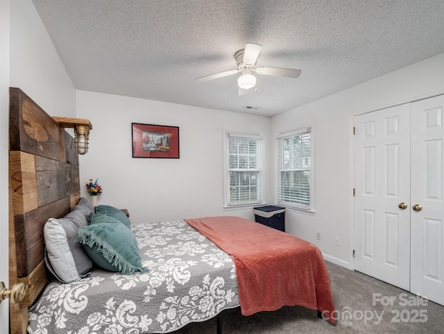 bedroom with carpet floors, a textured ceiling, ceiling fan, and a closet