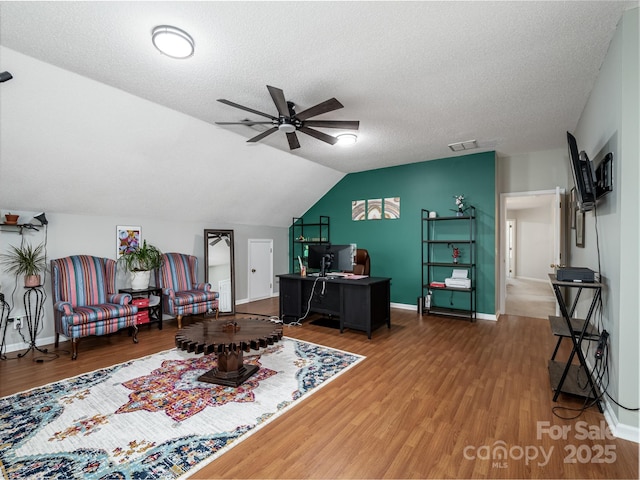 office featuring lofted ceiling, hardwood / wood-style floors, a textured ceiling, and ceiling fan