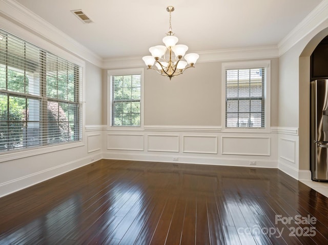 unfurnished dining area with a notable chandelier, dark hardwood / wood-style floors, and crown molding