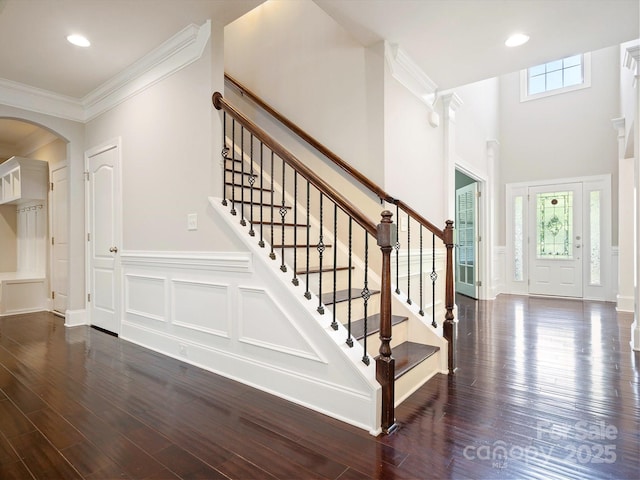 entrance foyer featuring dark hardwood / wood-style floors, a healthy amount of sunlight, and ornamental molding