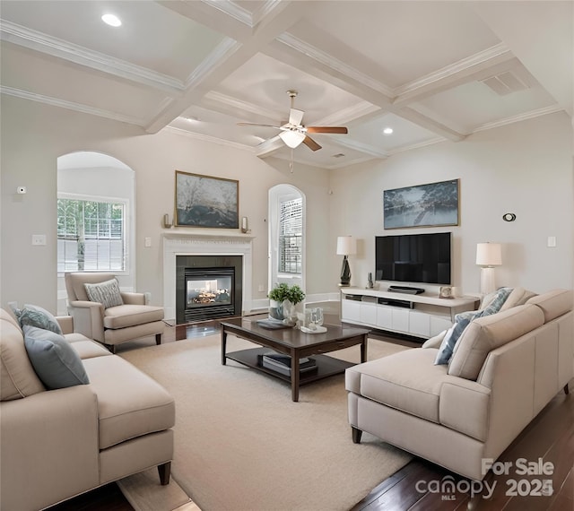 living room featuring beam ceiling, hardwood / wood-style floors, a multi sided fireplace, and coffered ceiling