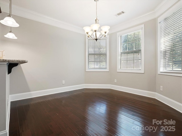 unfurnished dining area with wood-type flooring, a notable chandelier, and ornamental molding