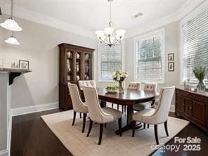 dining space featuring hardwood / wood-style flooring, an inviting chandelier, and crown molding