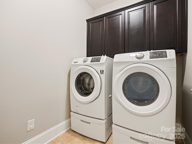 clothes washing area with cabinets, light tile patterned flooring, and washing machine and clothes dryer