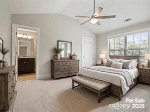 bedroom with light colored carpet, ensuite bath, ceiling fan, and lofted ceiling