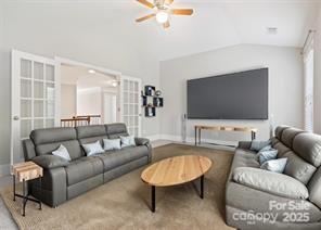 living room featuring vaulted ceiling and ceiling fan