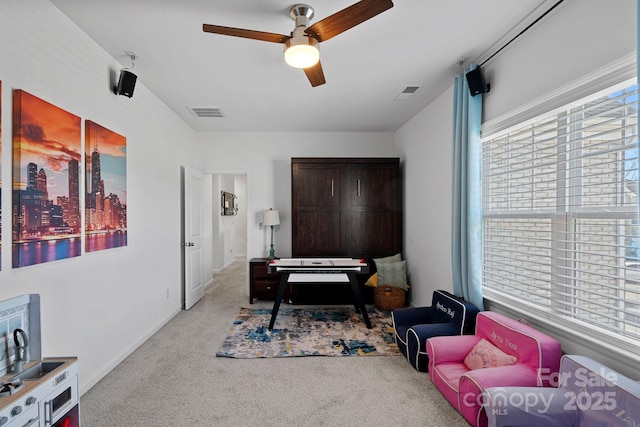 sitting room with light colored carpet and ceiling fan