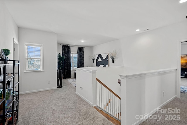 hallway featuring light colored carpet