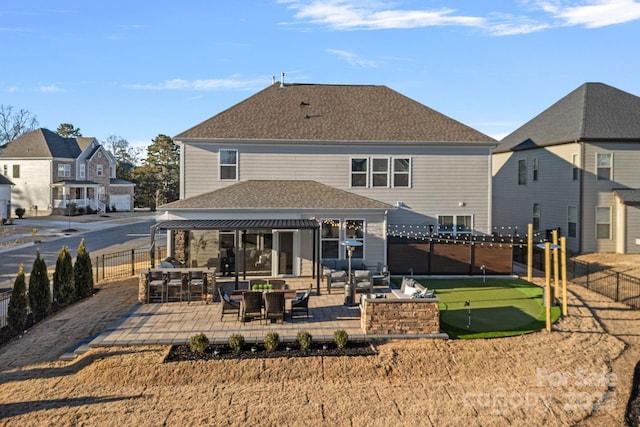 rear view of property with a patio, a shingled roof, fence, and a residential view