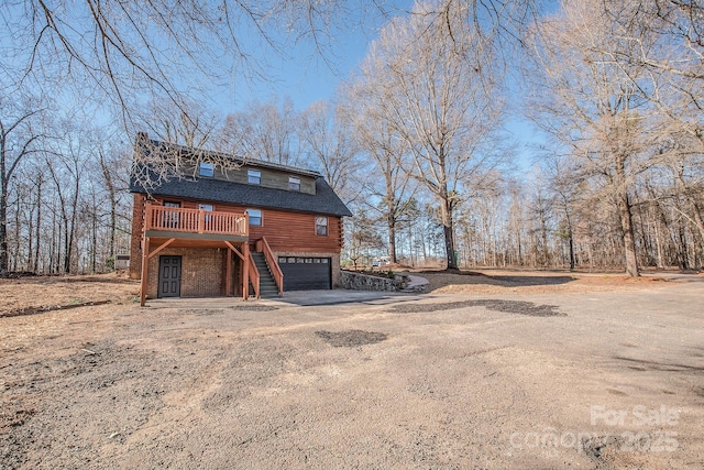 view of property exterior with a garage and a wooden deck