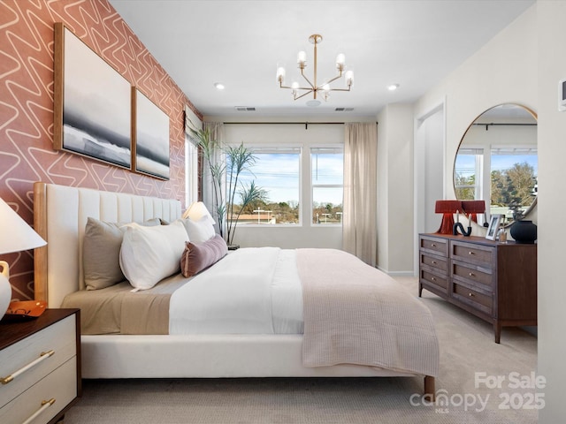 bedroom featuring an accent wall, multiple windows, carpet flooring, and visible vents