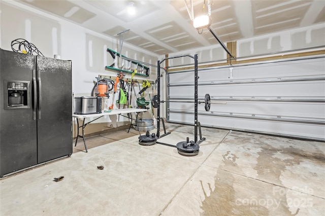 garage featuring black fridge and a garage door opener