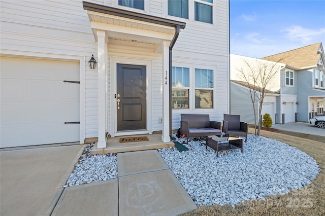 view of exterior entry featuring a garage and an outdoor living space