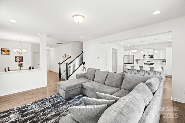 living room featuring an inviting chandelier and hardwood / wood-style floors