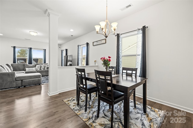 dining space featuring dark wood-type flooring, plenty of natural light, and a chandelier