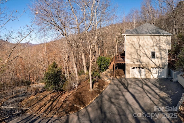 exterior space with a deck with mountain view and a garage