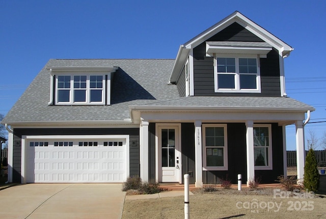 view of front of home featuring driveway, an attached garage, covered porch, and roof with shingles