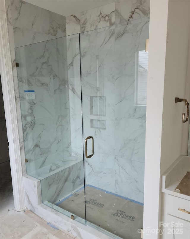 bathroom featuring a marble finish shower