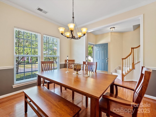 dining space featuring a chandelier, crown molding, and wood-type flooring