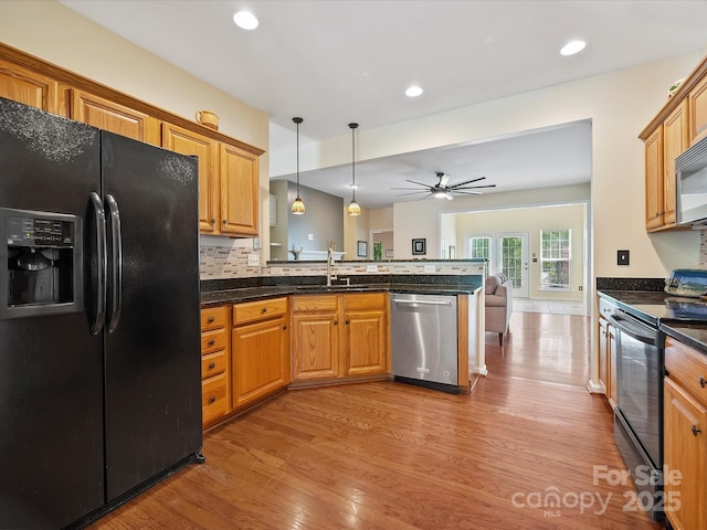 kitchen with kitchen peninsula, ceiling fan, black appliances, decorative light fixtures, and light hardwood / wood-style floors